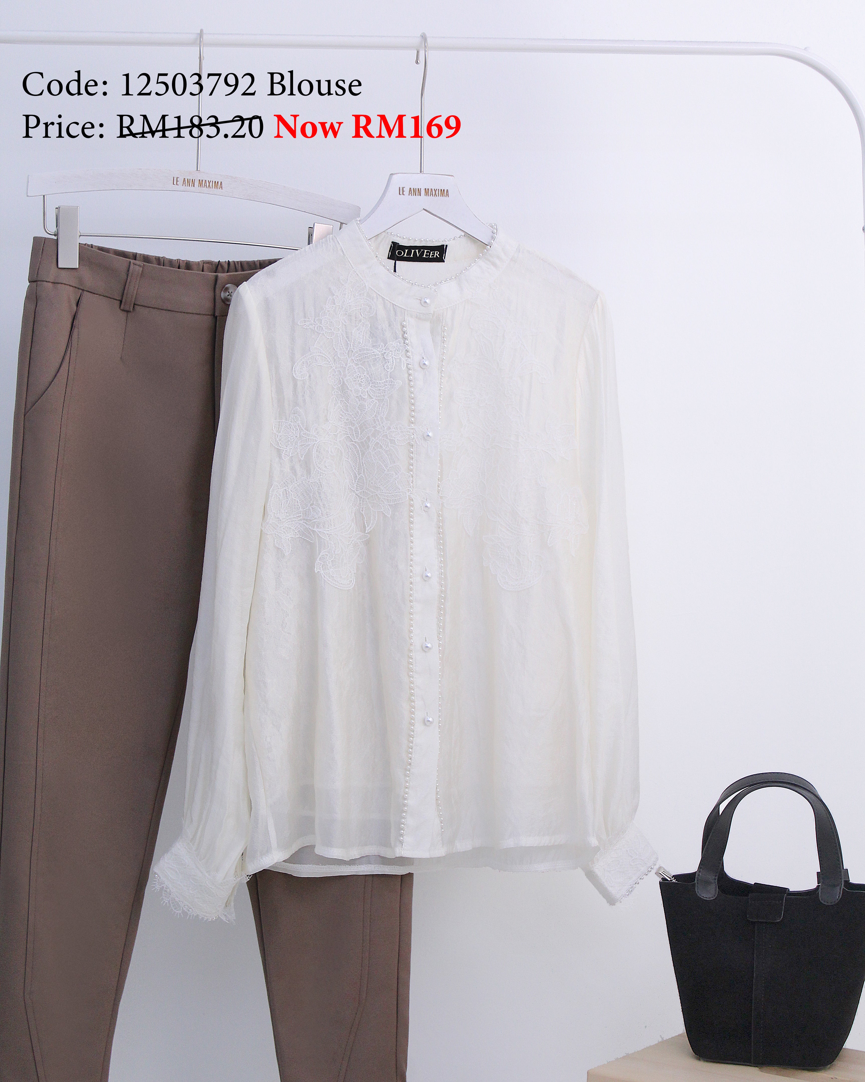 White blouse and brown pants on a hanger with a black handbag on a white background.