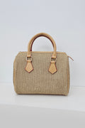 A structured straw handbag with tan leather handles and trim