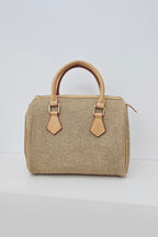 A structured straw handbag with tan leather handles and trim