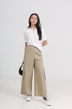 A woman modeling a white short-sleeve blouse and beige wide-leg cargo pants by Le Ann Maxima