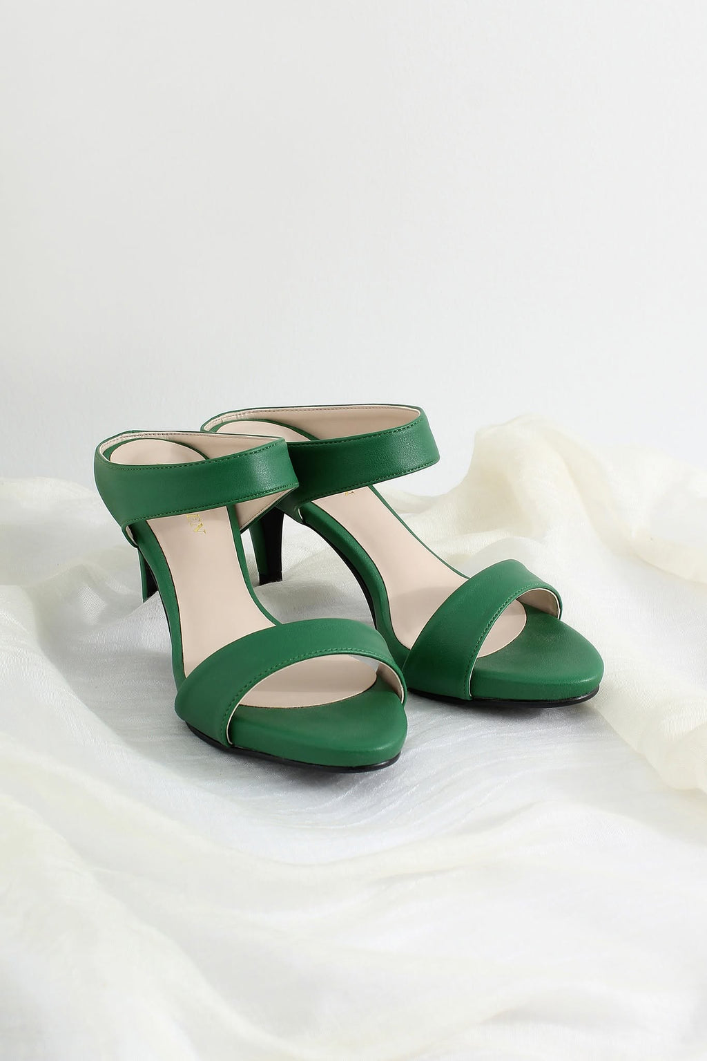 A pair of green open-toe high-heeled sandals with a single wide strap across the instep and a slingback ankle strap