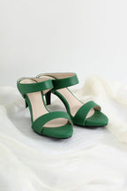 A pair of green open-toe high-heeled sandals with a single wide strap across the instep and a slingback ankle strap