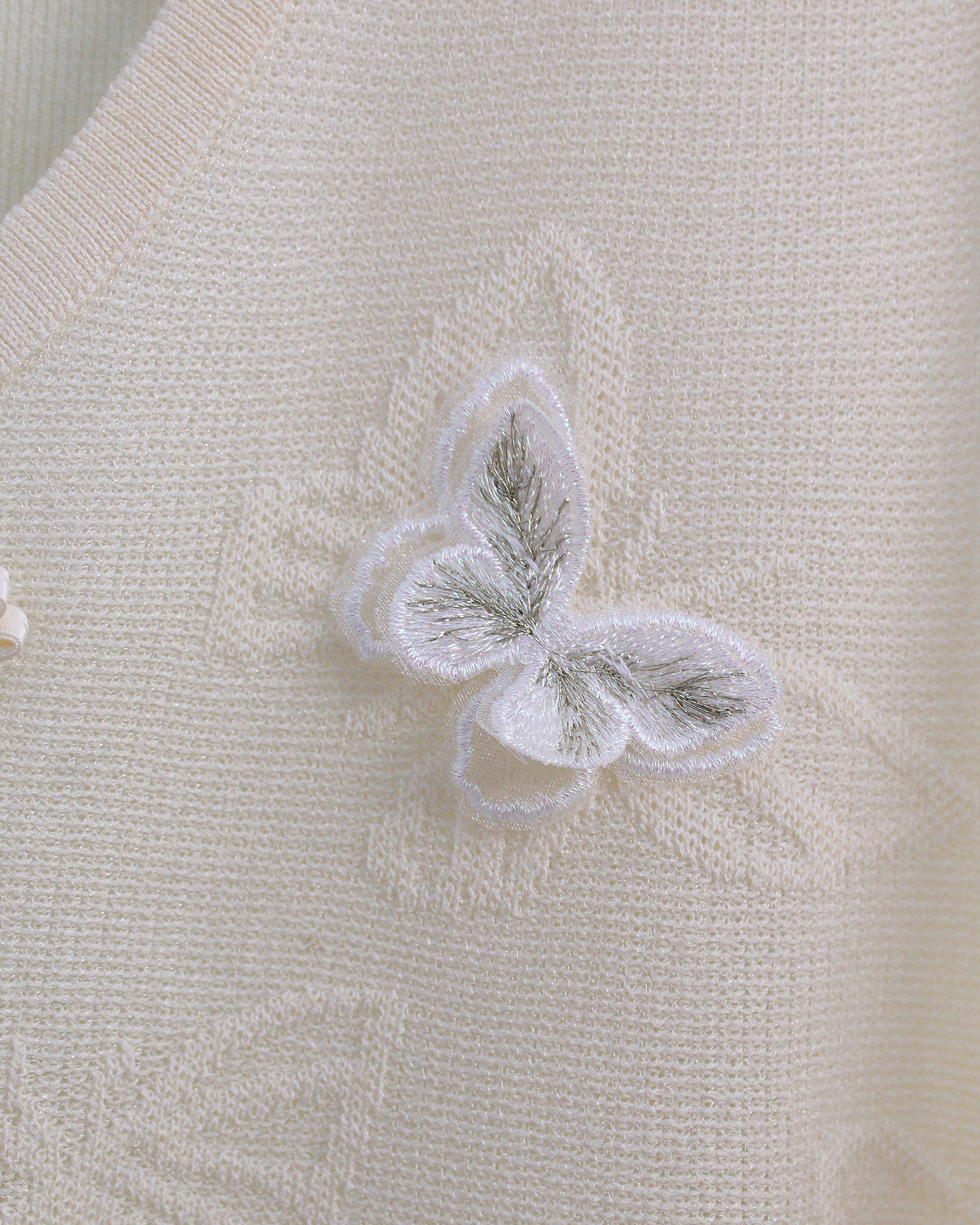 Close-up of a textured fabric surface with a butterfly design.