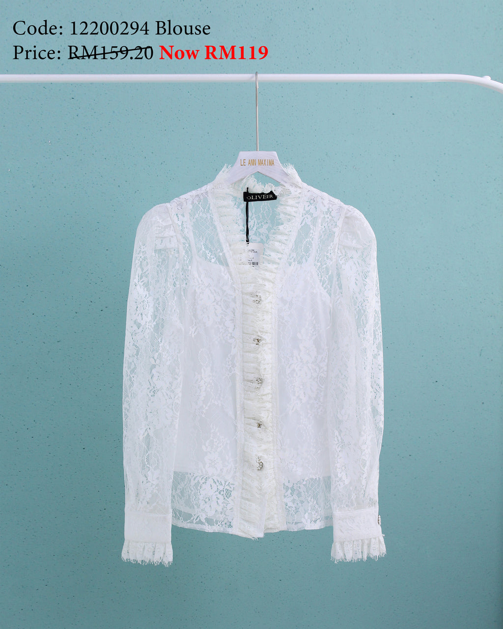 White lace blouse on a hanger against a light blue background