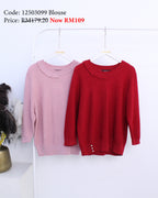 Pink and red blouses on hangers with price tags against a white background