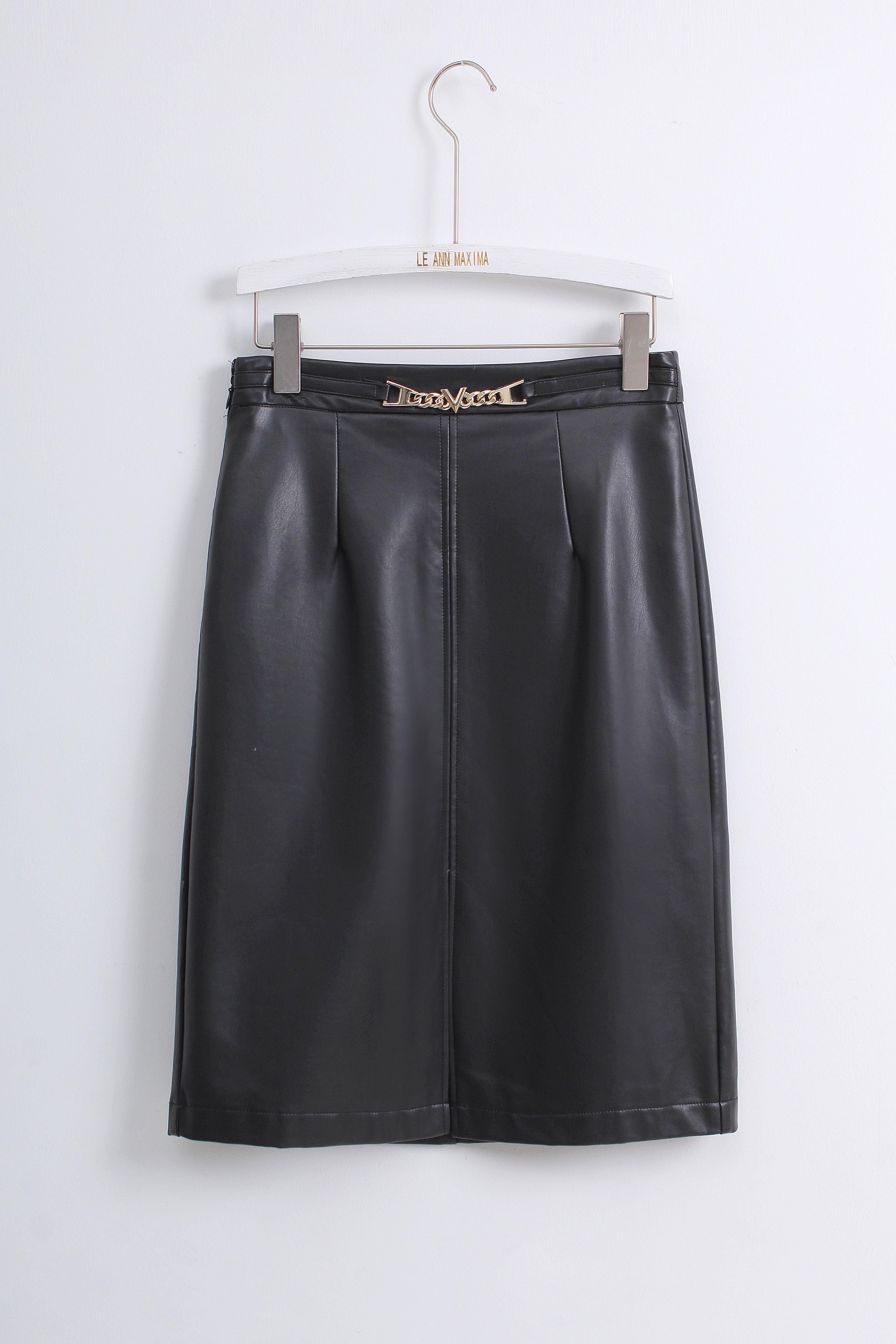 A black faux leather A-line skirt with pleated detailing and a gold-tone chain-link waistband, hanging on a white hanger against a light gray wall.