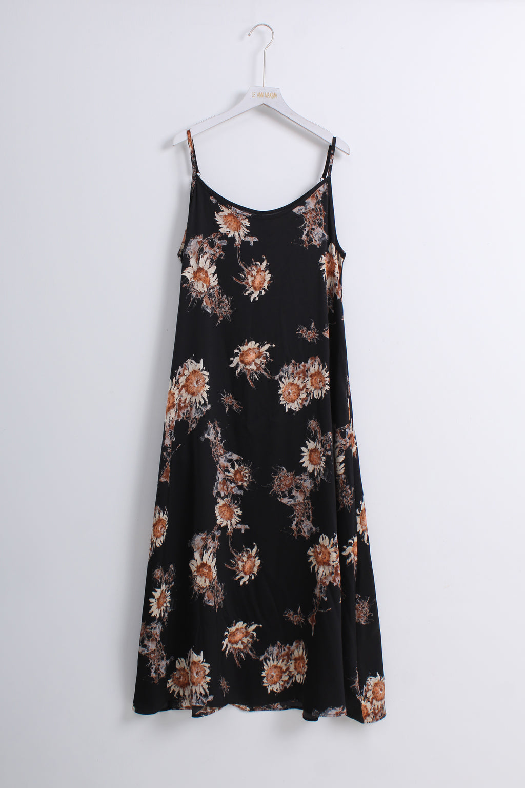 A black spaghetti-strap midi dress with a brown and beige floral pattern