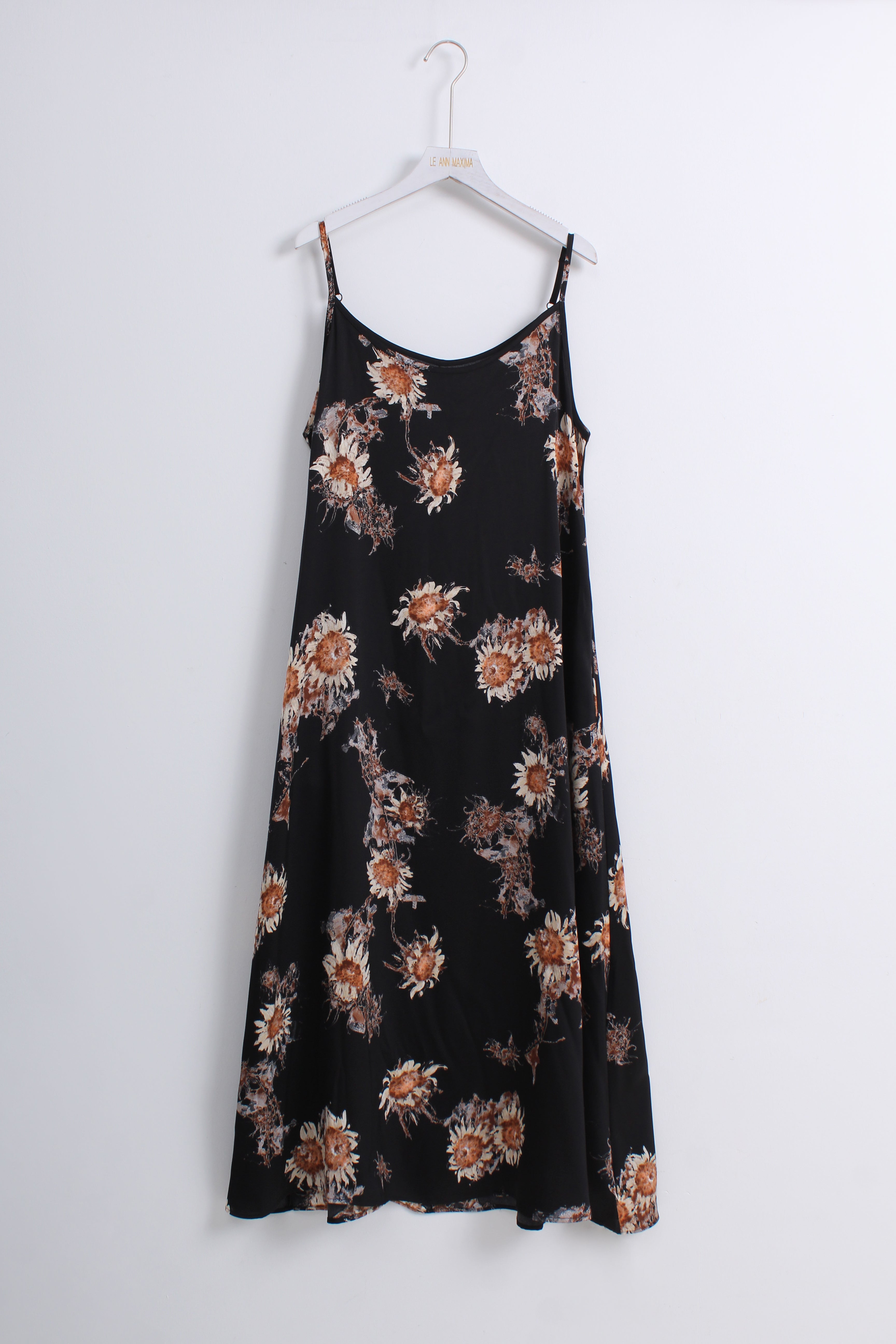 A black spaghetti-strap midi dress with a brown and beige floral pattern