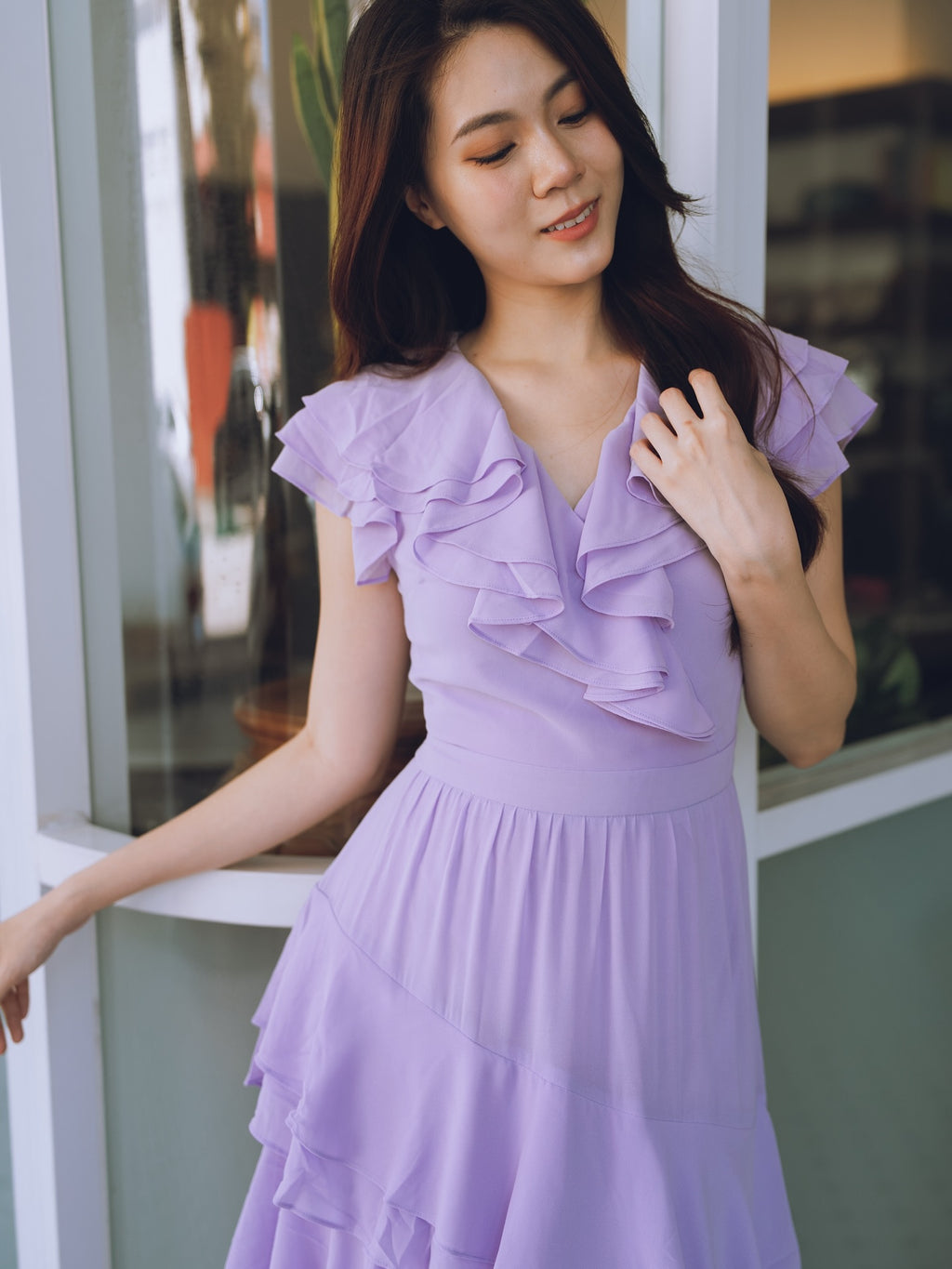 Woman wearing a purple lavender dress with ruffled details