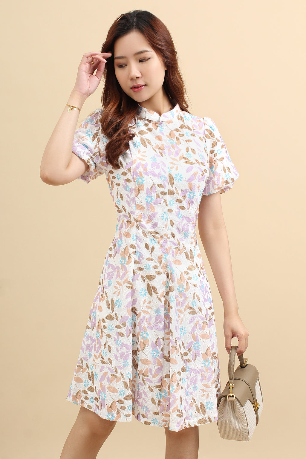 A woman wearing a purple floral printed mini dress with cotton eyelet and short puff sleeves