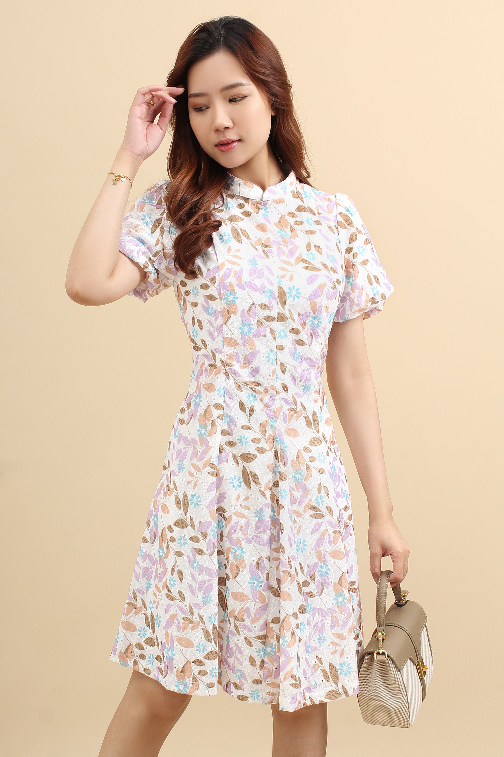 A woman wearing a purple floral printed mini dress with cotton eyelet and short puff sleeves