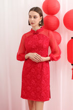 Woman wearing a red lace cheongsam dress with red lanterns in the background